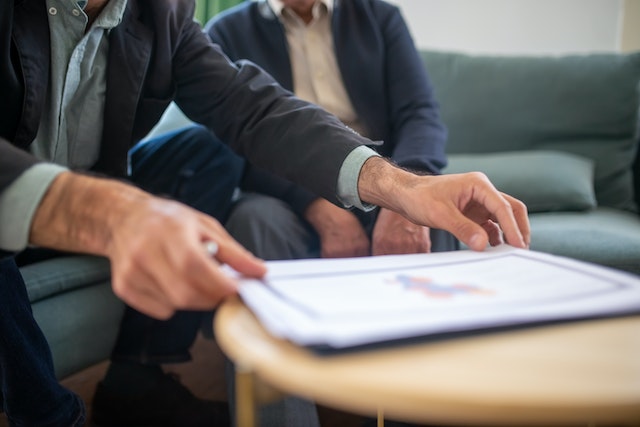 Photo by Kampus Production: https://www.pexels.com/photo/a-man-holding-documents-on-a-wooden-table-8439662/